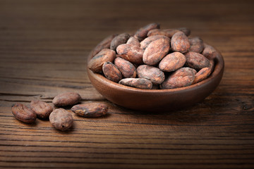 dried cacao beans on the old wooden board