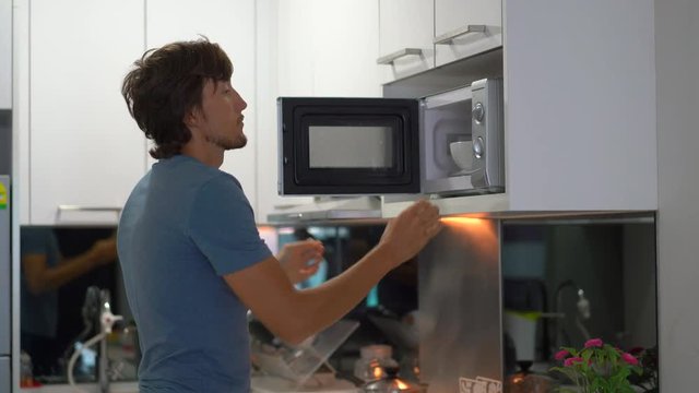 A young man on a kitchen preparing breakfast with fresh tropical fruits for his family