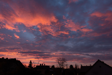 Sunrise with dramatic colorful sky over a city skyline silhouette