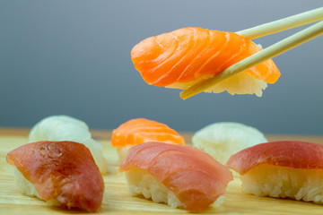 Fresh salmon sushi , salmon maki roll Japanese food restaurant, salmon sushi on plate. Sushi platter with a mixed variety of the Japanese delicacy at a buffet spread table.