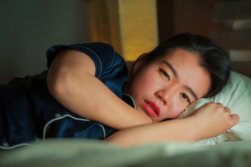 beautiful sad and depressed Asian Korean woman awake in bed late night suffering anxiety crisis and depression problem feeling desperate after relationship break up