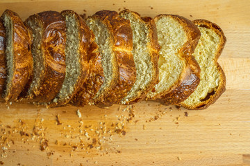 Slice Brioche toast loaf with bread crumbs on wood cutting board	