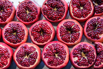 From above shot of red and ripe pomegranates cut in parts.