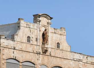 Fototapeta na wymiar Statue of Jesus Christ on a rooftop of College des Freres near the Jaffa Gate in old city of Jerusalem, Israel
