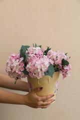 Hand hold buckets of fabric pink flowers