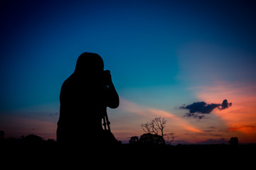 Naklejka premium Silhouette photographer with sunset