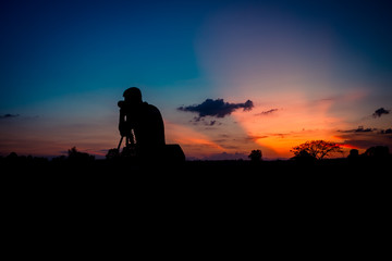 Obraz na płótnie Canvas Silhouette photographer with sunset