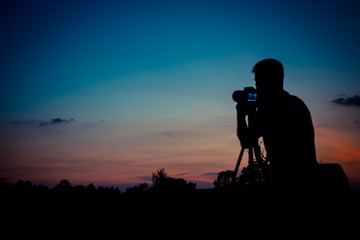 Fototapeta na wymiar Silhouette photographer with sunset