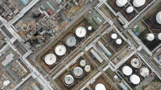 Aerial top down view over oil refinery and power plant with many storage tanks and pipelines. Shot with 4K UHD resolution drone