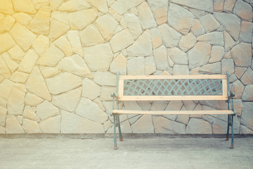 Vintage wooden chair with stone wall