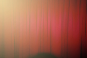 Red closed curtain with a light spo
