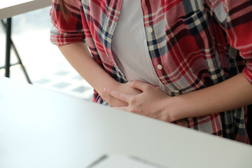 girl woman touching stomach with hurt pain suffering from stomachache menstrual period cramp