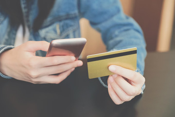 woman holding credit card using mobile smartphone for shopping online