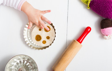 baby hands playing with craft knitted plush vegetables in children kitchen, directly above