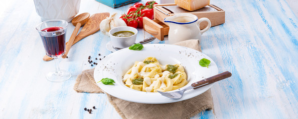Tortellini di formaggio with basil pesto and cheese sauce