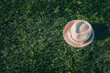 Summer background Pink sunhat on green grass. Pop art, creative summer party concept. Minimalism.