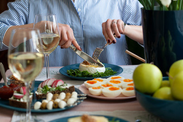 A gourmet lunch for two: grilled camembert, rye bread sandwiches, various appetizers and wine.