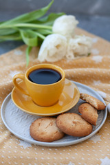 A tasty snack: a cup of coffee and a plate of cookies.