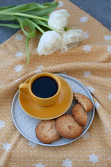 A tasty snack: a cup of coffee and a plate of cookies.