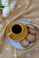 A tasty snack: a cup of coffee and a plate of cookies.