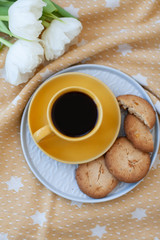 A tasty snack: a cup of coffee and a plate of cookies.