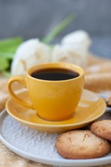 A tasty snack: a cup of coffee and a plate of cookies.