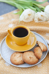 A tasty snack: a cup of coffee and a plate of cookies.