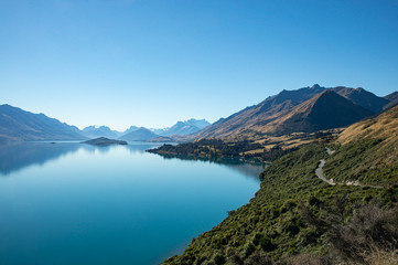 Naklejka na ściany i meble Gorgeous view of blue calm lake surrounding with mountains from viewpoint on the way to Glennorchy in South Island, New Zealand.