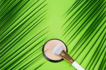 on a green background, there are two palm leaves on the edges, in the middle there is powder to...