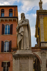 Monument to Dante Alighieri in Piazza dei Signori in Verona. Sunlight is enlightening statue of Dante Alighieri holding his chin.