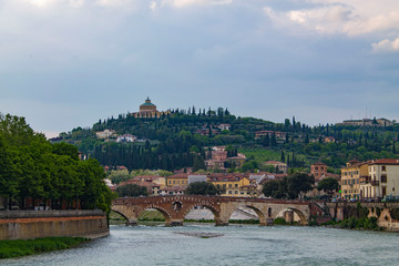 Verona Skyline with an arched bridge over the Adige River. Bright cityscape with a bend in the...