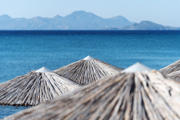 Umbrellas on Kardamena city beach in Kos island, Greece.