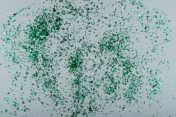 Beautiful small green glitter on a gray background.