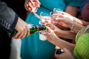 a man pours champagne on the glasses. Guests at the wedding pour champagne. Pouring champagne into a glass