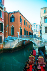 Picturesque view of ancient buildings, bridge and channel with gondolas in Venice, Italy. Beautiful romantic italian city. Unique Venetian landscape.