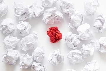 Social pressure concept. Flat lay of crumpled same color paper ball crowd around individual red one. White background.