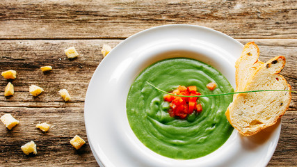 Healthy nutrition. Vegetable soup puree served with toasted croutons on rustic wooden background.