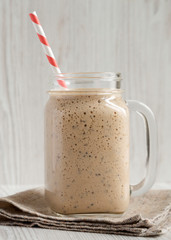 Banana kiwi apple smoothie in a glass jar, side view. Close-up.