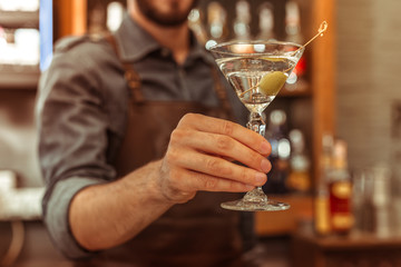 Close-up photo of bar worker holding a martini cocktail
