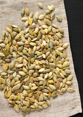 Roasted pumpkin seeds on cloth, top view. Flat lay, overhead, from above. Close-up.