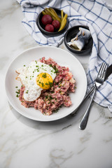 Norddeutscher Hamburger Labskaus mit Rindfleisch Corned Beef, Rote Beete, Kartoffeln, Saure Gurken, Spiegelei und Rollmops auf Teller
