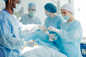 beautiful nurse giving scissors to afro doctor in glasses. close up side view photo