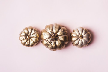 Golden pumpkins on pastel pink background. Autumn Holiday minimal concept