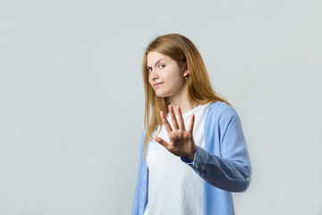 Emotional portrait of a red-haired girl on a gray background, stormy emotions, business concept.