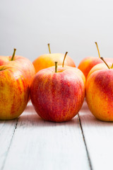 apple fruits in a row, white wooden table background