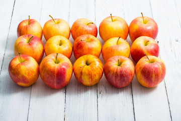 apple fruits in a row, white wooden table background