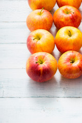 apple fruits in a row, white wooden table background