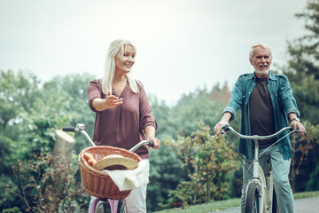 Positive active senior couple riding bikes together