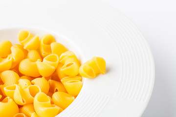 Dry Conchiglie pasta close up on white