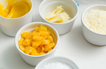 beeswax, emulsan, shea butter, cosmetic lotion cream diy do it yourself ingredients on white textile